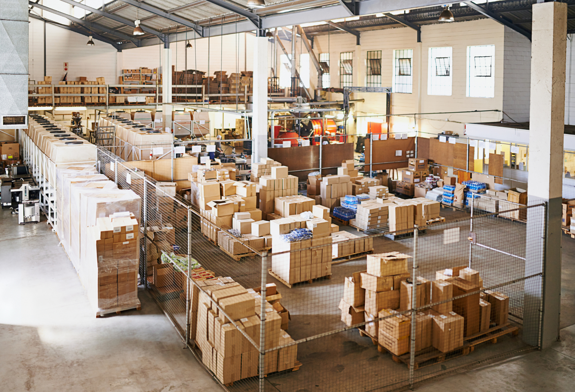 Inside a storage container with items stacked on pallets, labelled plastic boxes, and moisture absorbers placed safely near the door